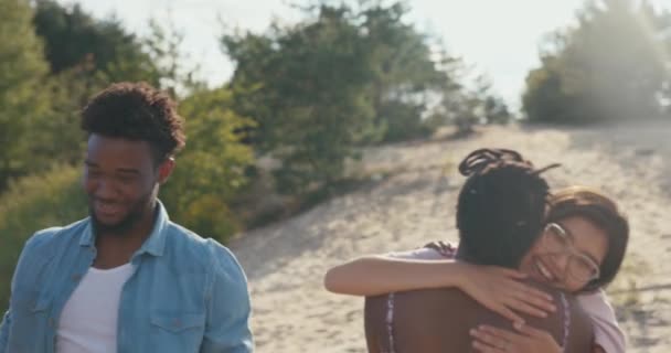 Los buenos amigos se encuentran en el lago todos se saludan calurosamente, abrazos, abrazos, alegría, felicidad, encuentro después de años, estudiantes, mucho tiempo sin vernos, sorpresa, chocar los cinco — Vídeos de Stock