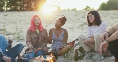Yaz akşamları kumsalda kamp ateşi, batan güneşin yanında üç kadın yan yana oturur, sosis, marşmelov kızartırlar, bira içerler, dedikodu yaparlar.
