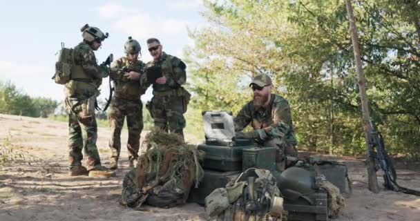 Група військовослужбовців встановила деталі дій малюків, які захищають територію, готує обладнання для експедиції в лісових солдатів, слідуючи картам ввести дані на комп'ютер і відправити інформацію на базу — стокове відео