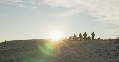 Askerler gün batımında görevlerinden ayrılır, kumlu arazide yürürler, kasklar takılır, moro üniformaları giyerler, tüfekler ellerinde, bölgeyi korurlar, üste toplanırlar, nöbetçi askerler