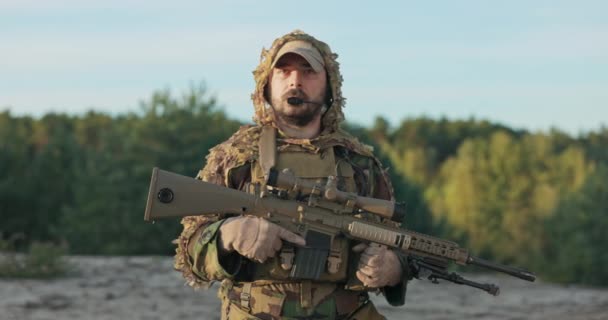Porträtt av soldat med allvarligt ansikte bär moro uniform, hjälm och bälte med utrustning man står vid uppmärksamhet gevär med pistol i händerna uppfyllelse av tjänst, försvar av landet, självuppoffring — Stockvideo