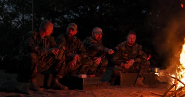 Ordu, eğitim alanlarında gece kamp kurdu. Isınmak için kamp ateşi yaktı ve çubuklarda sosis kızarttı. Askerler görev başındaydı. — Stok video