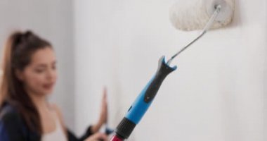 Gülümseyen güzel bir kadın daireyi çocukla boyar duvarları beyaza boyar son rötuşları elinde yapar taşınmadan önce ressam, dekoratör, boyacı olarak çalışır, boş zamanlarını resim yaparak geçirir.