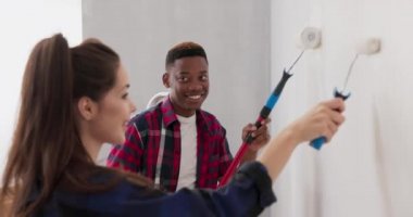 Aşık bir çift yeni satın aldıkları dairelerini yeniliyorlar. Duvarları küçük ve büyük bir silindir kullanarak beyaza boyuyorlar. Boyayı dikkatlice ve dikkatlice sürüyorlar.