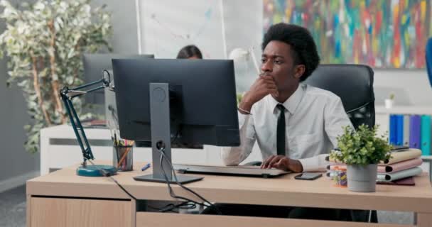 Ein erfahrener, gutaussehender Mitarbeiter in Hemd und Krawatte bereitet Dokumente am Computer vor, entwirft einen Artikel oder eine Rede, sendet Nachrichten an Kunden, tippt mit den Fingern auf der Tastatur — Stockvideo