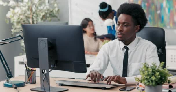 Un empleado experimentado de la empresa vestido con una camisa y corbata prepara documentos en el ordenador, redacta un artículo o un discurso, envía mensajes a los clientes, toca los dedos en el teclado — Vídeo de stock