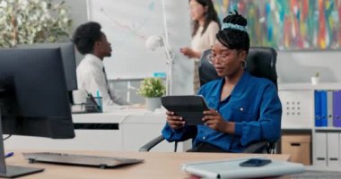 Şirketteki iş arkadaşları tahtada yeni bir proje üzerinde çalışıyorlar, bir grafik çiziyorlar, mavi gömlekli bir kadın onlara yardım etmiyor, elinde bir tablet tutuyor, oyunlar oynuyor.