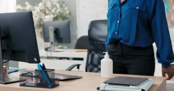 Eine attraktive Frau in Hemd und Brille kommt zur Arbeit, setzt sich an den Schreibtisch, desinfiziert ihre Hände mit einer Flüssigkeit, bevor sie mit den Fingern auf der Computertastatur klickt. — Stockvideo