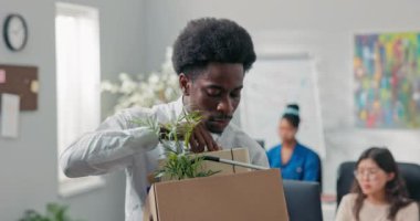 Saçları afro saçlı bir adam ofisten ayrılır kutuya tıkıştırılmış eşyalarla şirketten ayrılır, her şeyi aldığından emin olmak için çekler alır, işi bırakır, emekli olur, mutlu bir şekilde gülümser.
