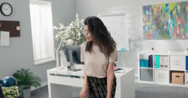 Trabalhador de escritório satisfeito feliz tem promoção ela dança entre mesas na companhia, mulher com beleza coreana é alegre, sorrindo, em uma pausa de seus deveres ela pratica uma nova coreografia — Vídeo de Stock