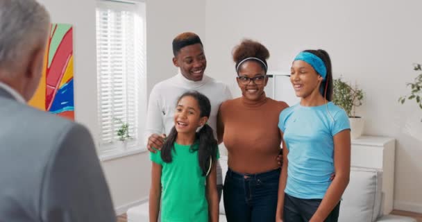 Усміхнена сім'я переглядає квартиру в оренду батьки приймають своїх дітей, вони уважно слухають досвідченого агента з нерухомості, який розмовляє з ним, обговорюючи деталі кидка — стокове відео