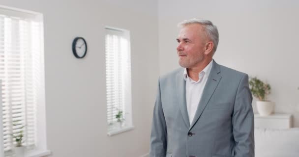 Hombre elegante en traje gris se levanta contra la pared blanca en la habitación, el tipo tiene los brazos cruzados en el pecho sonríe a la cámara agente de bienes raíces agente de seguros empleado corporativo oficinista hombre de negocios — Vídeos de Stock