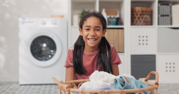 Uśmiechnięta ładna dziewczyna siedzi w środku łazienki, pralnia, przed dużym wiklinowym koszu wypełnionym kolorowe ubrania w rękach, córka pomaga matce w pracach domowych — Wideo stockowe