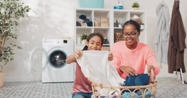 Dottern hjälper mamma med hushållssysslor, kvinnorna sorterar tvätt, viker kläder, förbereder dem för torkning, de tillbringar tid tillsammans i badrummet pratar leende — Stockvideo