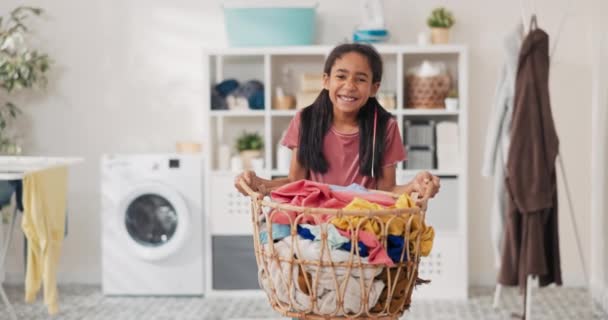 Uśmiechnięta ładna dziewczyna stoi na środku łazienki, pralnia, trzymając duży wiklinowy kosz wypełniony kolorowe ubrania w rękach, córka pomaga matce w pracach domowych — Wideo stockowe