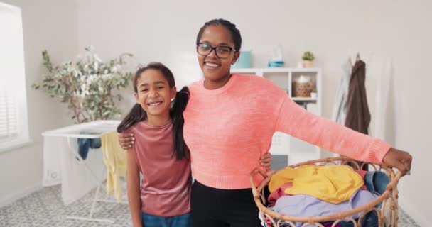 Femme et fille embrassent debout en arrière-plan de la buanderie salle de bain mère tient panier à linge en osier farci de vêtements colorés passer du temps ensemble tout en faisant des tâches ménagères — Video