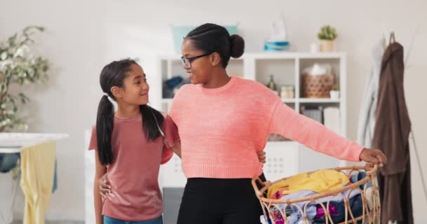 女人和女儿一起站在洗衣房的后面，妈妈拿着装有五颜六色衣服的柳条筐一起做家务活 — 图库视频影像