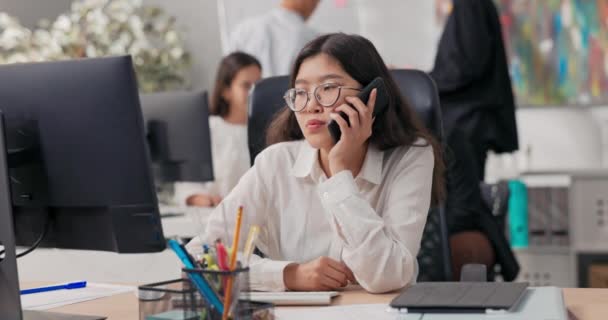 Uma secretária segurando chamadas telefônicas de um cliente, clica seus dedos no teclado do computador, não consegue alcançá-la uma mulher resignada olha para o monitor — Vídeo de Stock