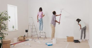 Genç bir baba ve kızı, karısının sürprizi olmadan bir daireyi yeniliyorlar. Beyaz boyalı rulo tutuyorlar ve duvarları boyuyorlar. Bir kız merdivene tırmanıyor.