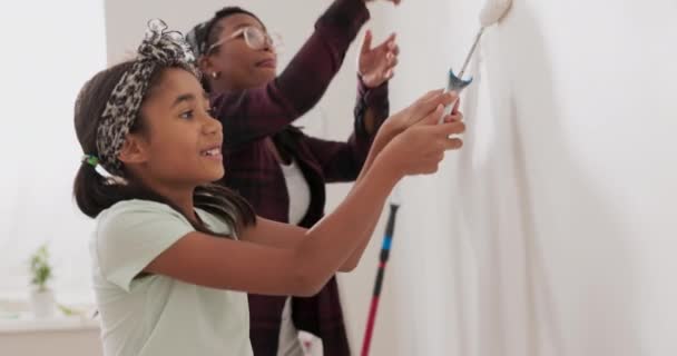 Maman passe du temps avec sa fille l'engage à aider ensemble ils peignent les murs de l'appartement rénové appliquer de la peinture blanche avec des rouleaux imbécile autour de jouer — Video