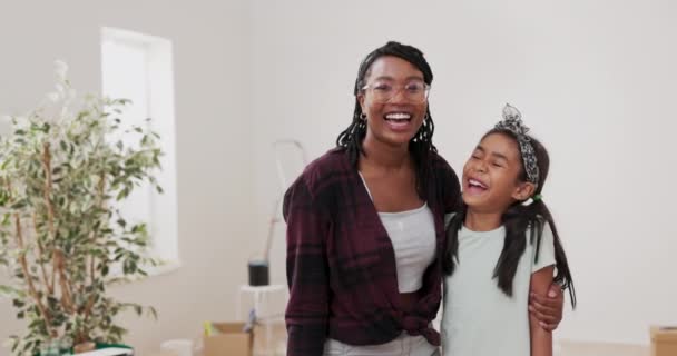 Mladá žena objímají a objímají svou mladší sestru dceru společně se dívají na fotoaparát s úsměvy smích odpočívá po malování stěn renovace místnosti — Stock video