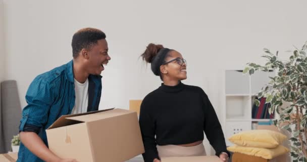 A married couple moves into a newly purchased apartment they hold boxes in their hands they look around them they are joyful excited about the amount of space available — Stock Video