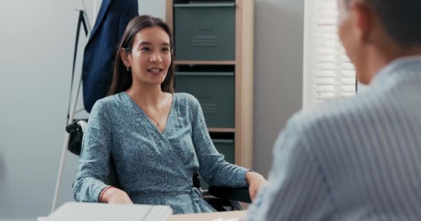 Bella bella donna asiatica coreana si siede sulla sedia a rotelle, è disabile, dopo un incidente, sta facendo domanda per un lavoro d'ufficio parlando con il capo dell'azienda, risponde alle domande poste spiega abilità — Video Stock