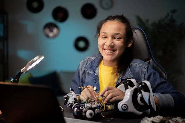 Mutlu genç kız robotik yetenekler geliştiriyor, elektrik oyuncaklarını tamir ediyor, kabloları, kabloları bağlıyor, okul projesi için kendi robotunu yapıyor.