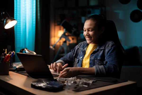 Een meisje zit 's avonds achter de computer, scrollend op laptop, surfen op het internet, surfen op sociale netwerken, online winkels, op zoek naar nuttige informatie Rechtenvrije Stockafbeeldingen