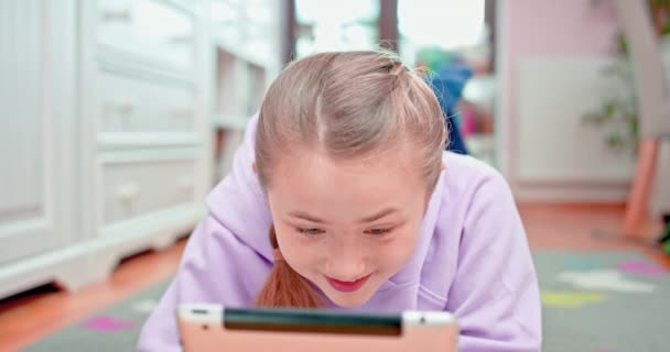 Menina adolescente está sorrindo quando toca no tablet. — Vídeo de Stock
