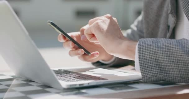Detailní záběr mužských rukou, který pracuje na notebooku a posouvá smartphone — Stock video
