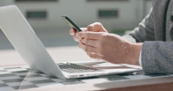 Close-up de mãos masculinas que está trabalhando no laptop e rolando o smartphone — Vídeo de Stock