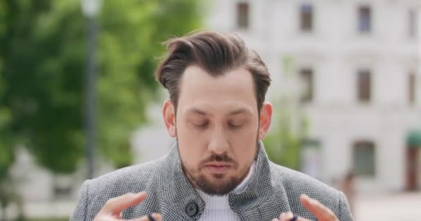 Junger Mann mit Schnurrbart und Bart trägt im Freien eine schwarze Schutzmaske — Stockvideo