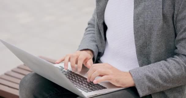 Zbliżenie młodych mężczyzn ręce, który siedzi na ławce na placu, wpisując na klawiaturze laptopa — Wideo stockowe