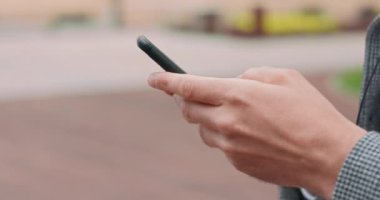 Sırtını direğe dayamış, akıllı telefon kamerasına mesaj yazan genç adamların ellerine yakın çekim yapmak sağdan sola hareket etmektir.