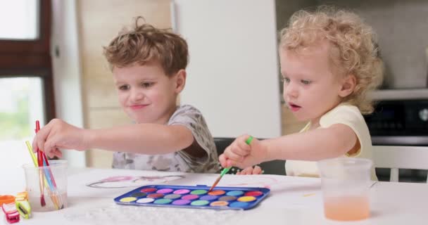 Fratele și sora desenează acuarele în timp ce stau la masă — Videoclip de stoc