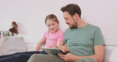 Baba ve genç kız oturma odasında kanepede oturuyor, çevrimiçi mağazayı geziyor, hafta sonunun keyfini çıkarıyor. Babam bazı makaleler hakkında ne düşündüğünü soruyor.