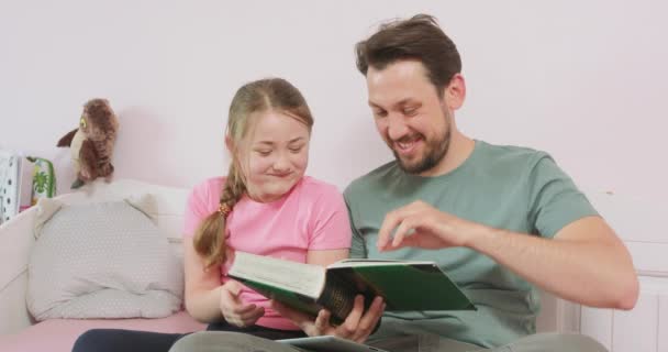 Ojciec i nastoletnia córka siedzą na kanapie i patrzą na zdjęcie — Wideo stockowe