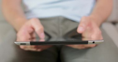 Erkeklerin ellerini ve avuçlarını kapalı tutarken, tablet kullanırken, muhtemelen bir oyun oynarken ya da bir şeyler kaydırırken elleri, avuçları ve göbeği bulanık.