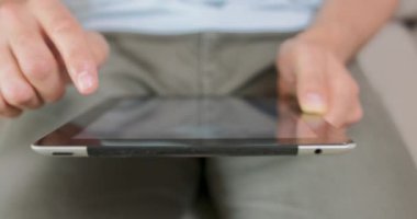 Erkeklerin ellerini ve avuçlarını kapalı tutarken, tablet kullanırken, muhtemelen bir oyun oynarken ya da bir şeyler kaydırırken elleri, avuçları ve göbeği bulanık.