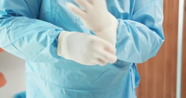 Närbild manliga veterinär händer, medan han bär kirurgiska handskar i operationssalen I bakgrunden - vita väggar och dörr — Stockvideo