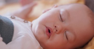 Gri battaniyenin altında uyuyan güzel bebeğe yaklaş.