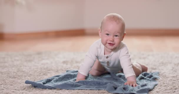 Közelkép a kis baba mászik a szőnyegen és takaró a padlón, emelkedik mind a négy fehér fal a háttérben — Stock videók