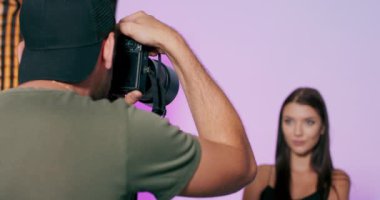 Profesyonel kamerayla fotoğraf çeken bir fotoğrafçıya beyaz ırk pozu veren çekici bir model.