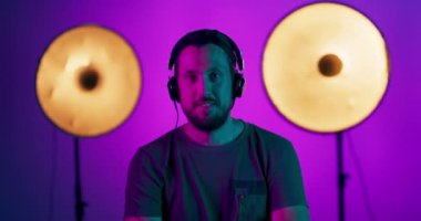 Stüdyoda gülümseyen genç bir adamın Retro dalga portresi. Moda erkek modeli. Stüdyo arka planında parlak ışık pozu veriyor.