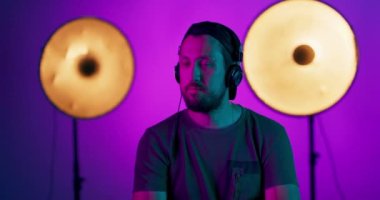 Güzel orta yaşlı bir adam pembe stüdyo arka planında izole edilmiş modern tasarım erkek modeli kulaklıkla poz veriyor yüz ifadesi kavramı, yaz, tatil, müzik, açık hava