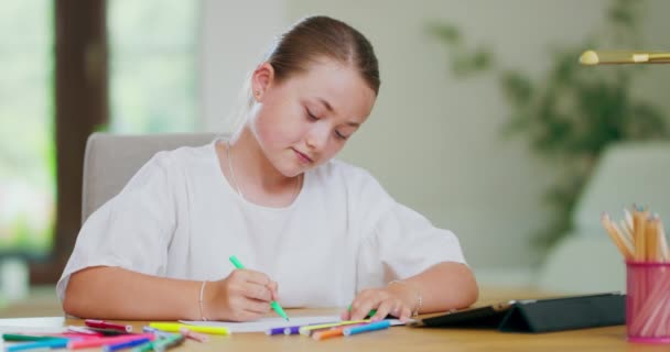 Nahaufnahme fokussiert lächelndes Teenie-Mädchen, am Schreibtisch, zeichnet mit grünen Filzstiften auf weißem Papierblatt und blickt auf Tablet vor sich auf dem Schreibtisch Erster Plan und Hintergrund verschwimmen — Stockvideo