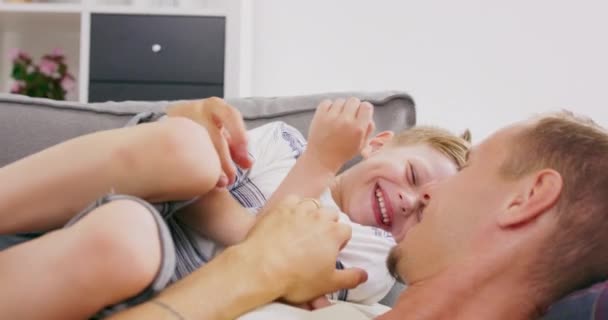 Cariñoso caucásico familia joven adulto padre cosquillas poco adorable niño hijo divertirse riendo relajarse en sofá, polaco papá jugando con pequeño niño niño vinculación abrazos juntos en casa — Vídeos de Stock