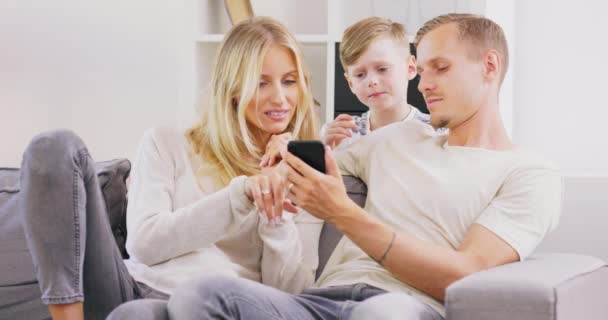 Belos pais jovens e seu filho bonitinho estão usando um tablet digital e sorrindo enquanto passam o tempo juntos — Vídeo de Stock