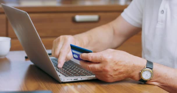 Zamknij palce mans trzymając plastikową kartę kredytową Starszy człowiek rezerwacji hotelu za pomocą on-line app serwisu i strony internetowej, dokonać płatności online, zakupy przez internet koncepcji — Wideo stockowe